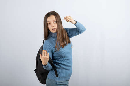 Portrait photo of a young girl model standing with backpack and posingの写真素材