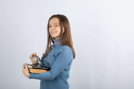 Picture of a young girl student holding books and glasses