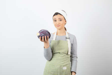 Picture of displeased woman posing with purple cabbage on white backgroundの写真素材