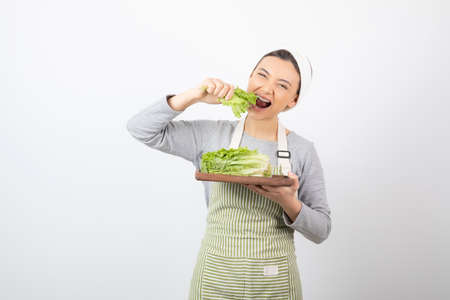 Portrait of a pretty cute woman eating fresh lettuceの写真素材