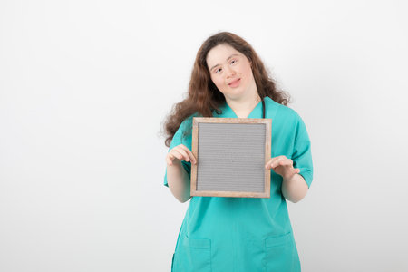 Image of a young girl in green uniform holding a frame