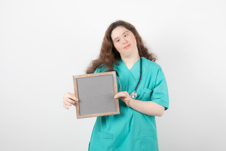 Image of a young girl in green uniform holding a frame