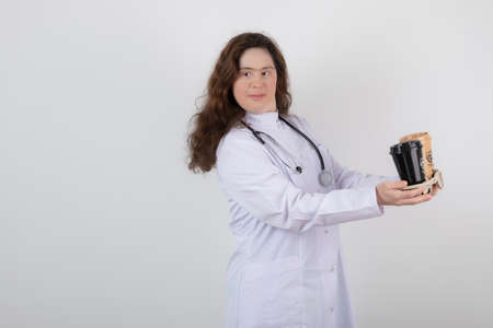 Picture of a young girl model in white uniform holding a cardboardの写真素材