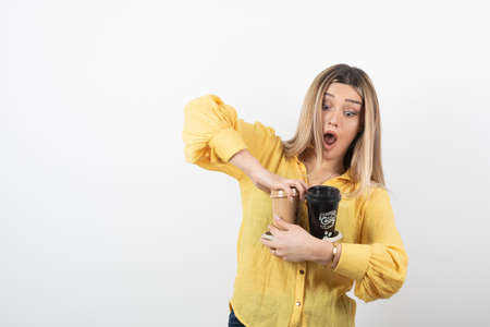 Image of young person holding cups of coffee on white background
