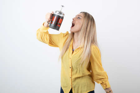 Image of a young pretty woman model holding a teapot