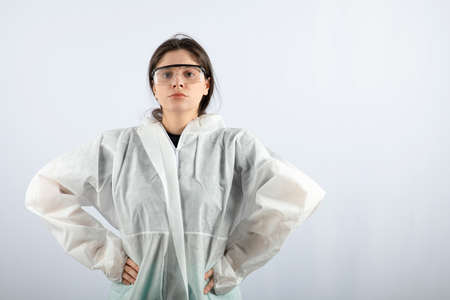 A young serious woman in defensive coat and goggles looking at cameraの写真素材