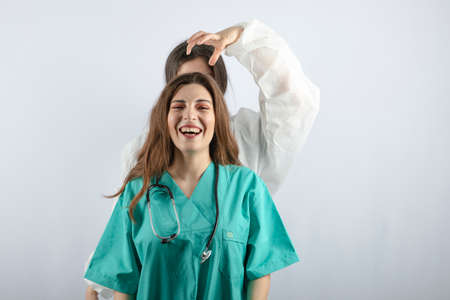 Young beautiful nurse in green uniform smiling while womanの写真素材