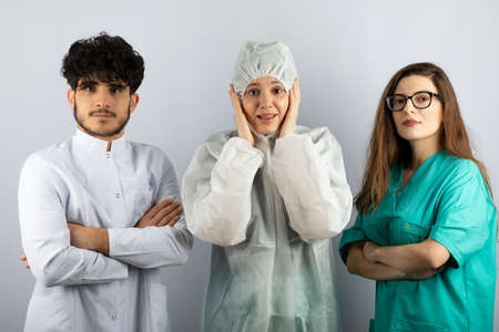 Three doctors standing and looking at camera on white backgroundの写真素材