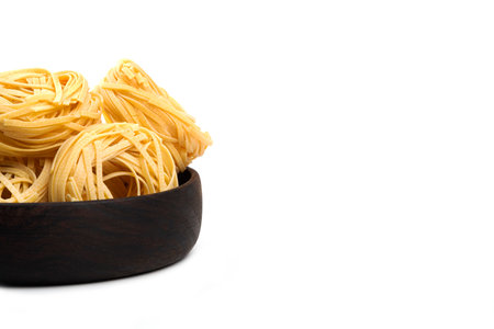 A wooden bowl full of twisted in the shape of a nest of portionsの写真素材
