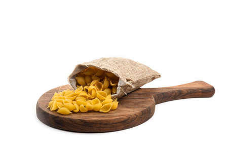 Conchiglie rigate pasta or seashell macaroni in sack isolated on white background.の写真素材