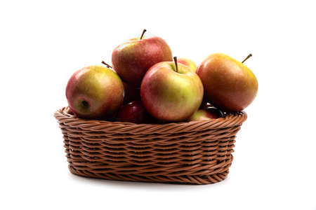 Wicker basket of fresh juicy apples isolated on white backgroundの写真素材
