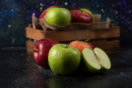Wooden box of fresh organic apples on black backgroundの写真素材
