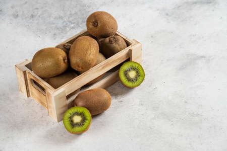 Many of fresh kiwi fruits on a wooden basketの写真素材