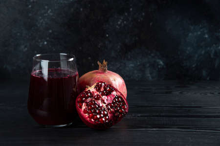 A glass cup of pomegranate juice on a dark backgroundの写真素材
