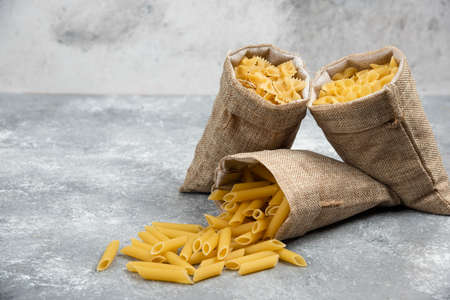 Pasta fusilli in a wooden bowl on wood background