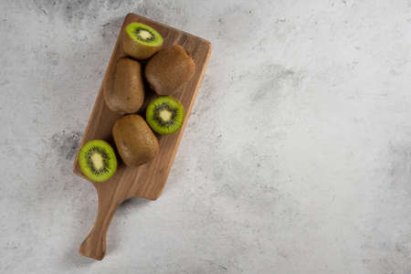 Many of fresh kiwi fruits on a wooden board