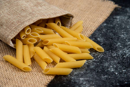 Raw pasta varieties on a piece of burlapの写真素材
