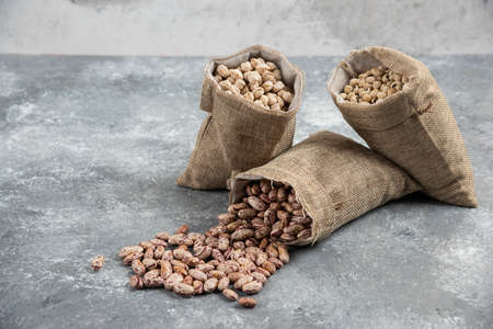 Sackcloth of organic raw beans placed on marble surface. High quality photoの写真素材