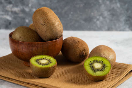 Bowl with delicious kiwi fruits on a brown tableclothの写真素材