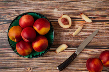 Red and yellow peaches in a green platterの写真素材