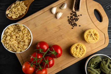 A bunch of tomatoes with italian pasta around