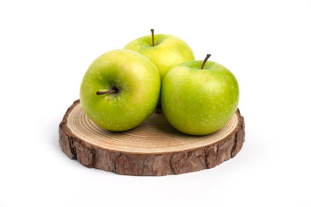Three fresh whole and sliced apples on wooden pieceの写真素材