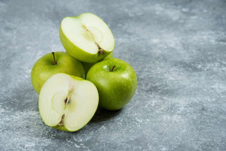 Three fresh whole and sliced apples on wooden pieceの写真素材