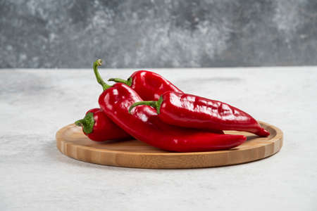 Bunch of hot chili peppers on wooden plateの写真素材