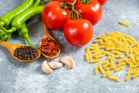 Fresh red tomatoes and chili peppers on marble backgroundの写真素材