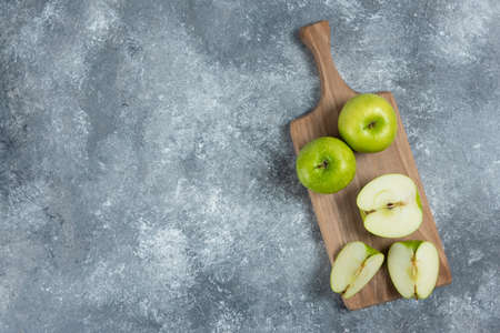 Fresh whole and sliced apples on wooden boardの写真素材