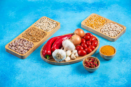 Variety of spices, vegetables and raw beans on blue backgroundの写真素材