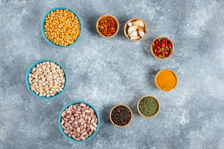 Bunch of spices and bowls of beans, corns on marble backgroundの写真素材