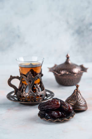 Traditional tea table. Tea and dry dates on grey backgroundの写真素材
