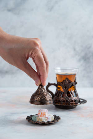 Tea Table. Man opening candy crockery beside of teaの写真素材