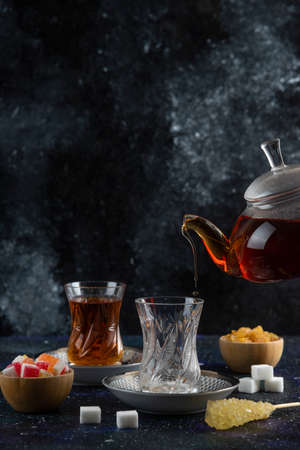 Vertical photo of tea table. Pouring tea to the glassの写真素材