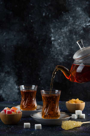 Vertical photo. Pouring tea to the glassの写真素材
