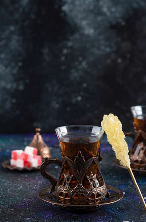 Vertical photo of Sweet colorful candies and fragrant tea on blue backgroundの写真素材