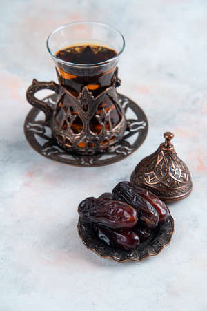 Vertical photo of dry dates and fresh tea on grey backgroundの写真素材