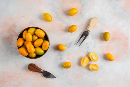 Top view of kumquats in the bowl and on groundの写真素材