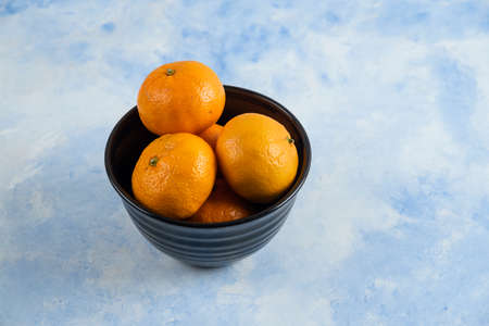 Close up photo of Clementine mandarins in black bowlの写真素材