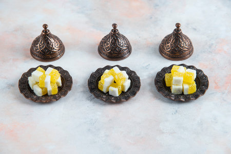 Candy crockery and yellow candies in a row over white backgroundの写真素材