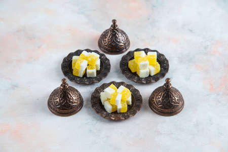 Yellow candies on crockery over white backgroundの写真素材