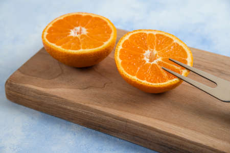 Close up photo of half cut clementine mandarin on wooden boardの写真素材