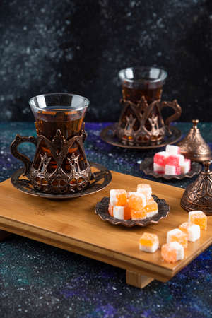 Vertical photo of Tea set with Turkish delights on wooden boardの写真素材