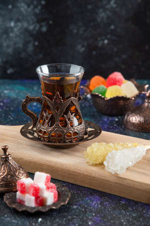 Vertical photo of Hot tea and sweet candies on wooden baordの写真素材