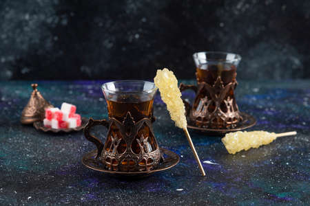Sweet colorful candies and fragrant tea on blue background. High quality photoの写真素材
