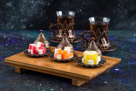 Colorful candies with fragrant tea on blue backgroundの写真素材