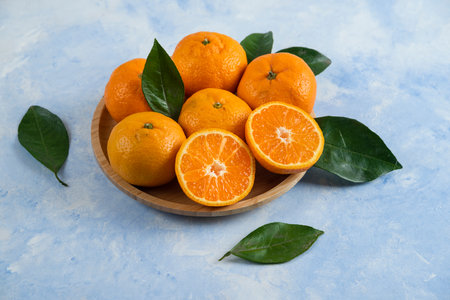 Close up photo of pile of clementine mandarin on wooden plateの写真素材