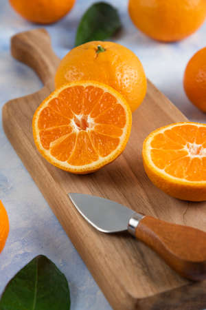 Close up photo of half cut mandarin on wooden cutting boardの写真素材