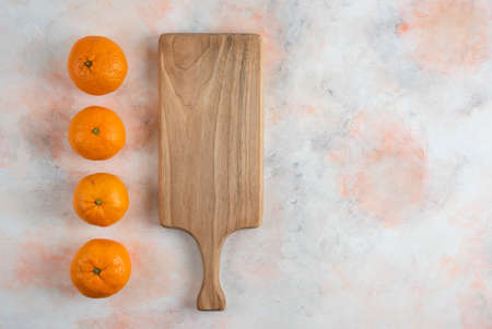 Fresh clementine mandarins in a row behind of wooden boardの写真素材